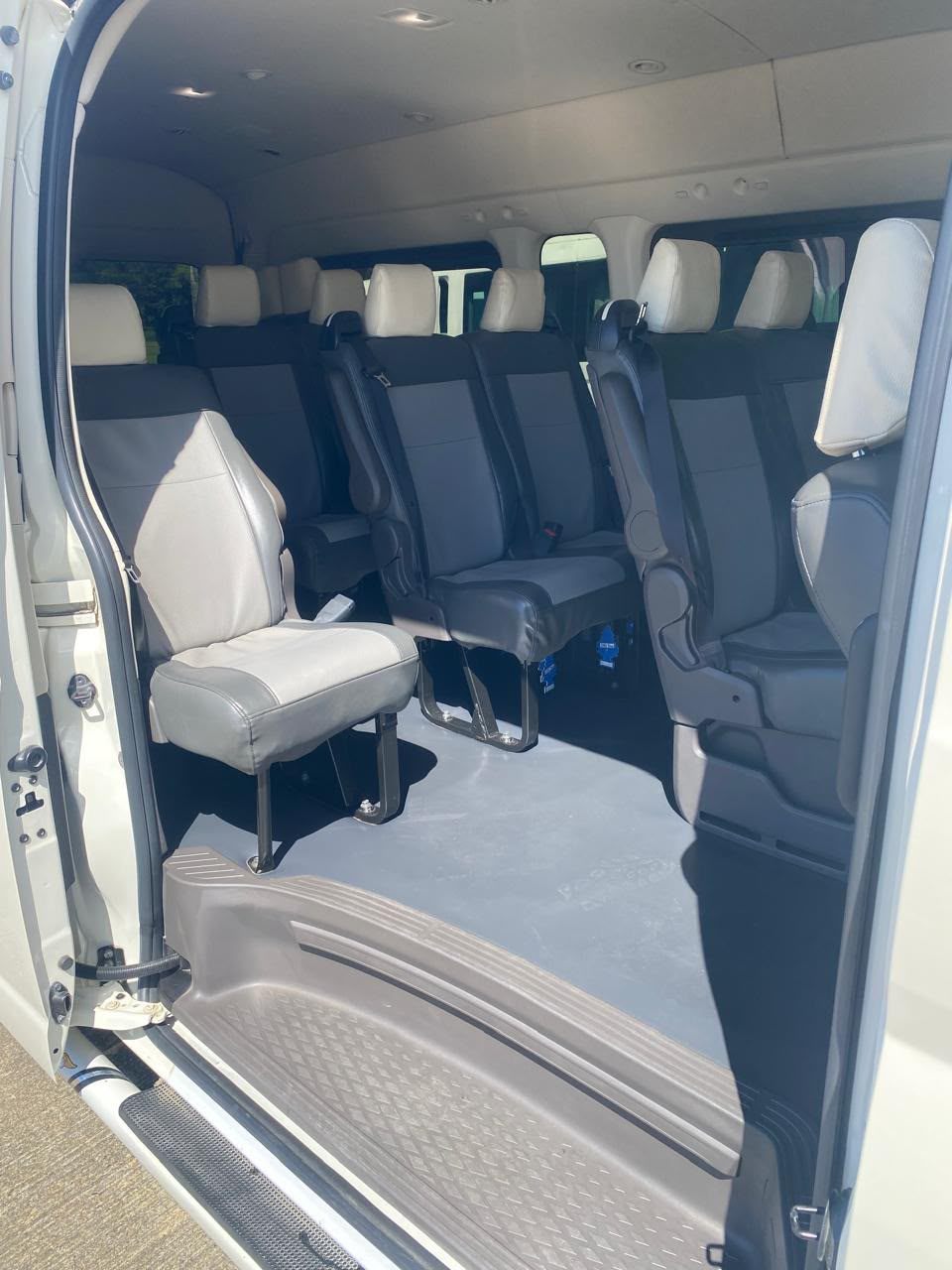 Grey leather seats inside a Toyota Hiace van with the door open
