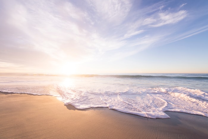 Soft waves washing over sand at first light