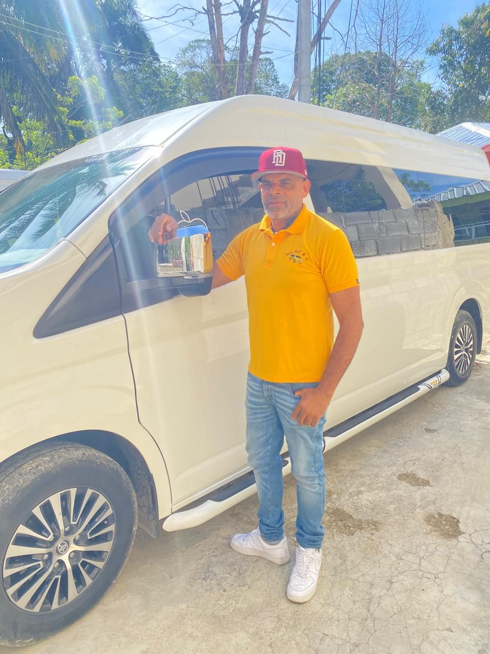 Saul, one of our drivers, standing beside a white Toyota Hiace van