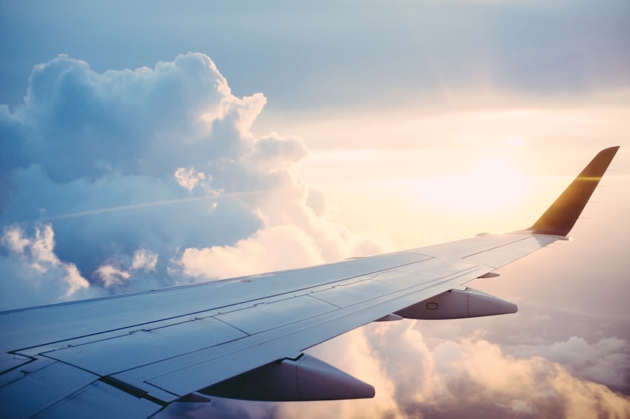 Airplane wing over golden clouds during landing approach