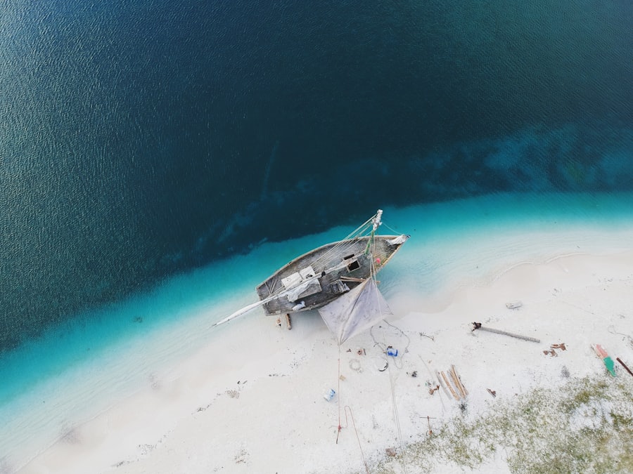 Sailboat anchored on white sand surrounded by turquoise Caribbean water