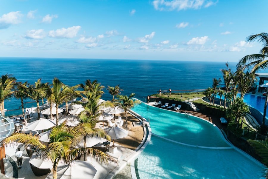 Aerial view of a beachfront resort pool surrounded by palm trees